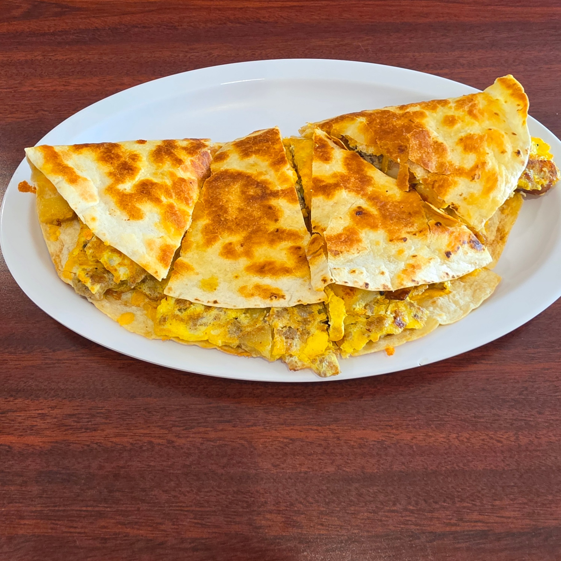 Breakfast Quesadilla at Toasted Cafe — Sausage, egg and cheese folded in a crisp tortilla, served with salsa and sour cream — a top seller every morning.
