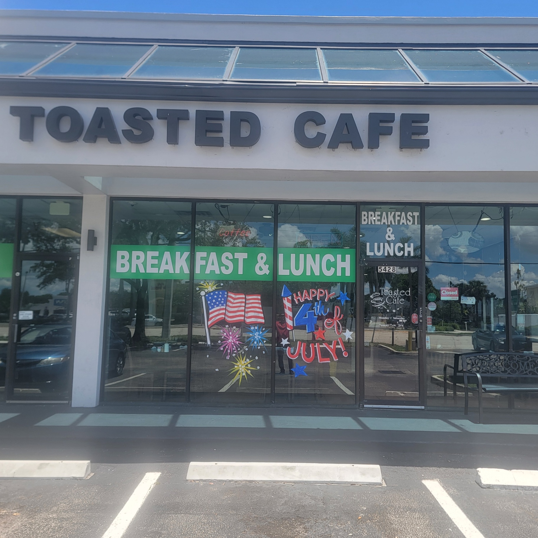 Wide view of Toasted Cafe storefront with 4th of July window art