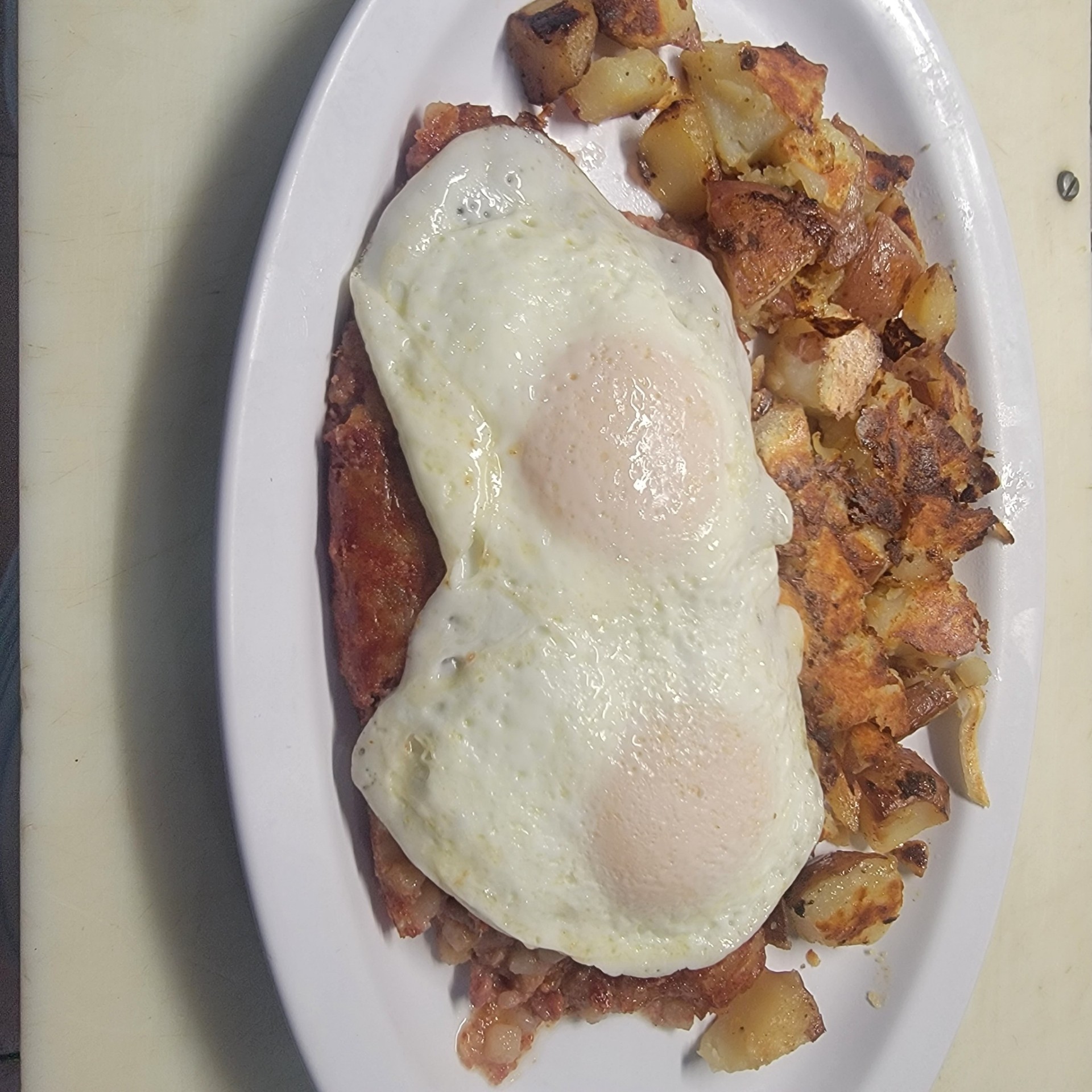 Corned beef hash with a fried egg and home fries