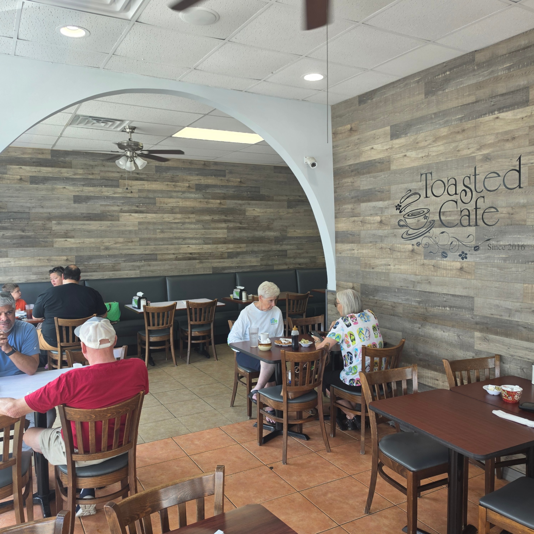 Toasted Cafe dining room with wood-plank wall and logo